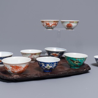 Nine various Chinese wine cups on an engraved wooden tray, 19/20th C.